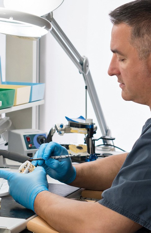 Dental technician working on a pair of dentures