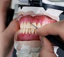 Dental technician working on a pair of dentures