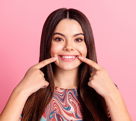 Woman pointing to her smile