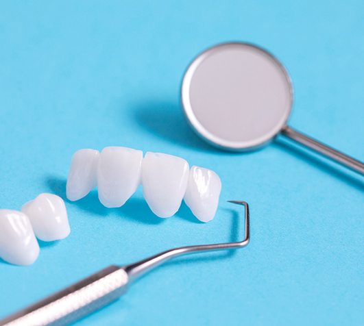 a closeup of a dental bridge against a blue background