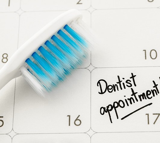 Dentist holding polishing brush to patient’s teeth