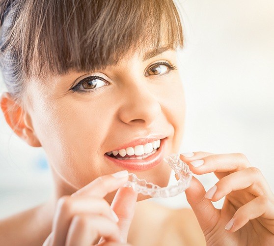 Woman placing Invisalign clear aligner tray