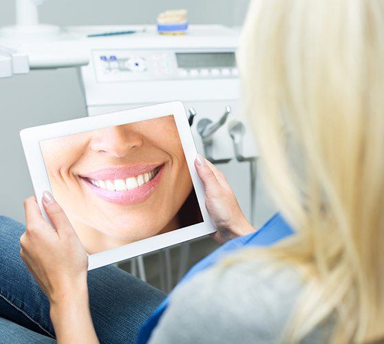 Dental team member looking at digital imaging on tablet computer