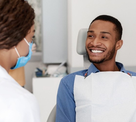 a patient smiling while visiting his dentist in New Bedford