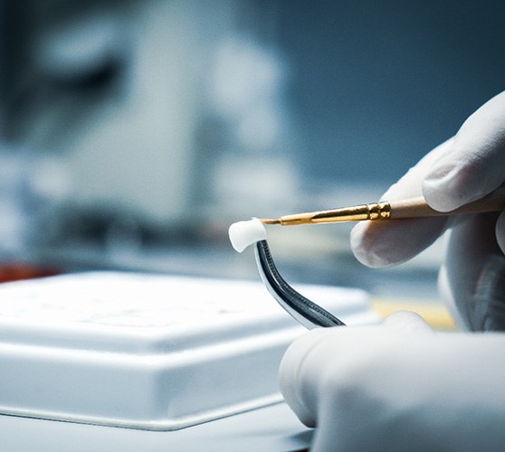 A lab worker processing a dental crown