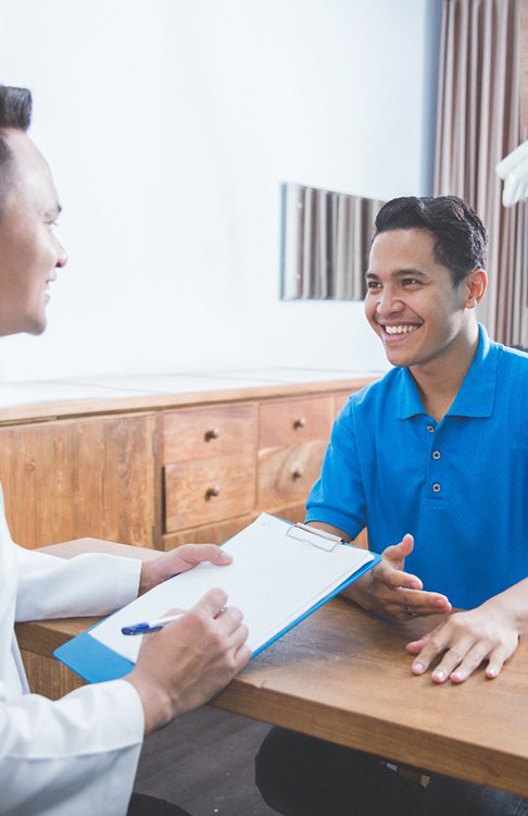 a dentist speaking with a patient about getting dentures