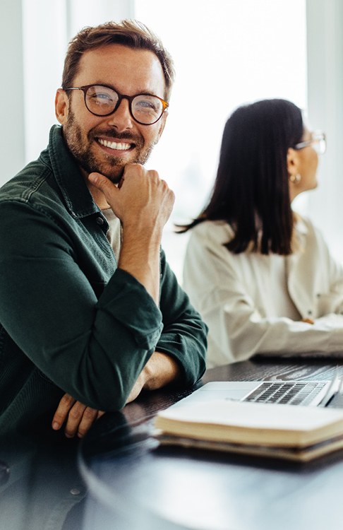 a man smiling and sitting at a table