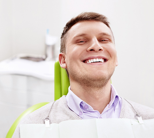 Man smiling while visiting New Bedford emergency dentist