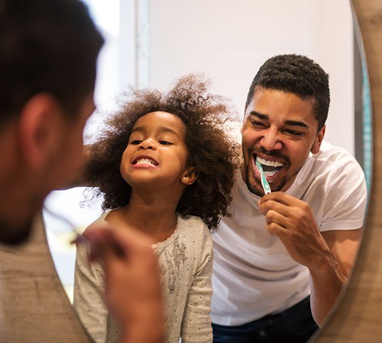 Father and child brushing teeth to prevent dental emergencies
