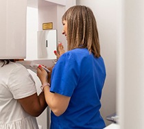 Dentist operating a CBCT scanner for a patient