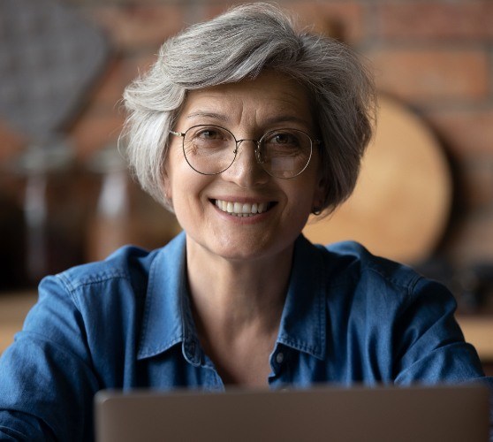 Woman sharing smile after dental implant tooth replacement