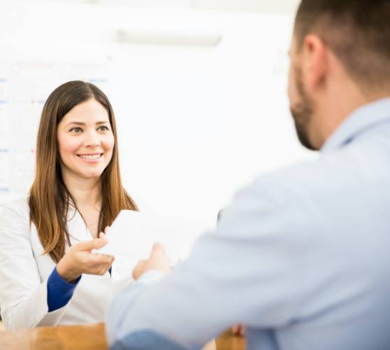 Dental team member and patient discussing the cost of dental implants