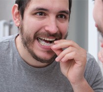 man putting on mouthguard  