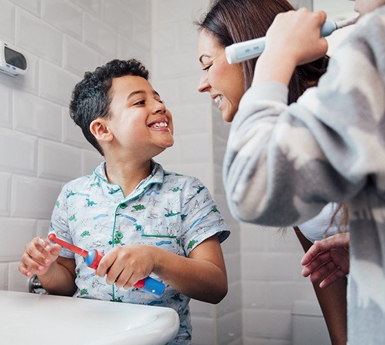 Mother and children using at home dental hygiene products