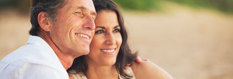 Man and woman with healthy smiles after dental implant supported tooth replacement