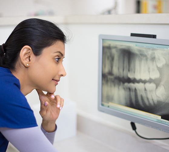 Dental team member looking at digital x-rays