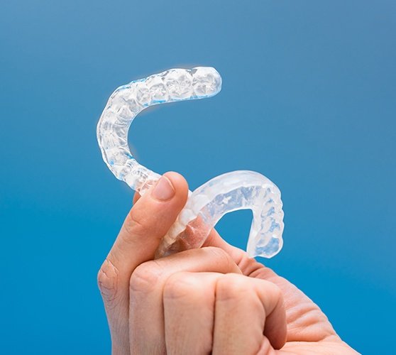 Hand holding a set of occlusal splints