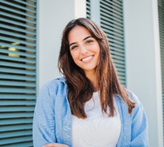 Woman with white teeth smiling while standing outside