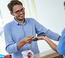 A man using a credit card to pay the cost of veneers