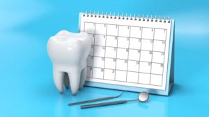 Tooth and dental instruments next to calendar