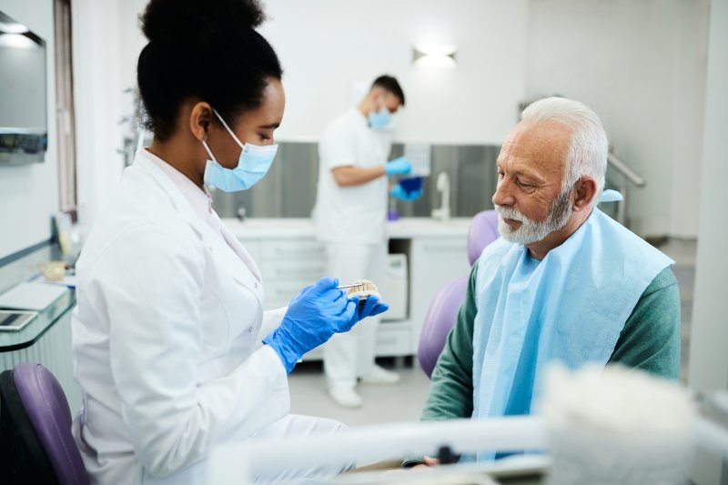 A dentist talking to her patient about dentures