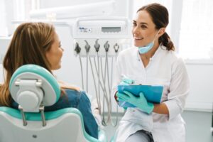 Dentist conversing with patient. 